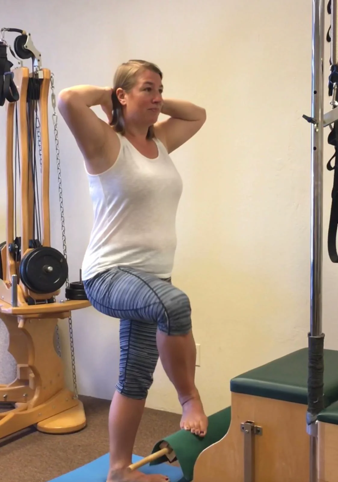 A student standing tall through a hip and spine exercise in the studio