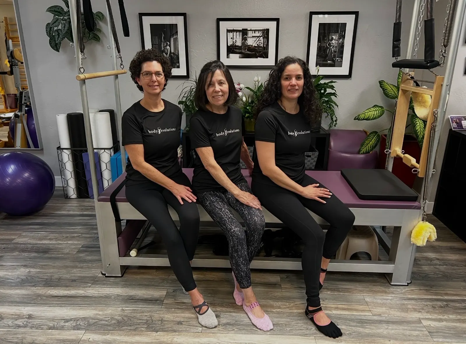 Three Body Evolutions instructors seated together on a reformer in the Campbell studio